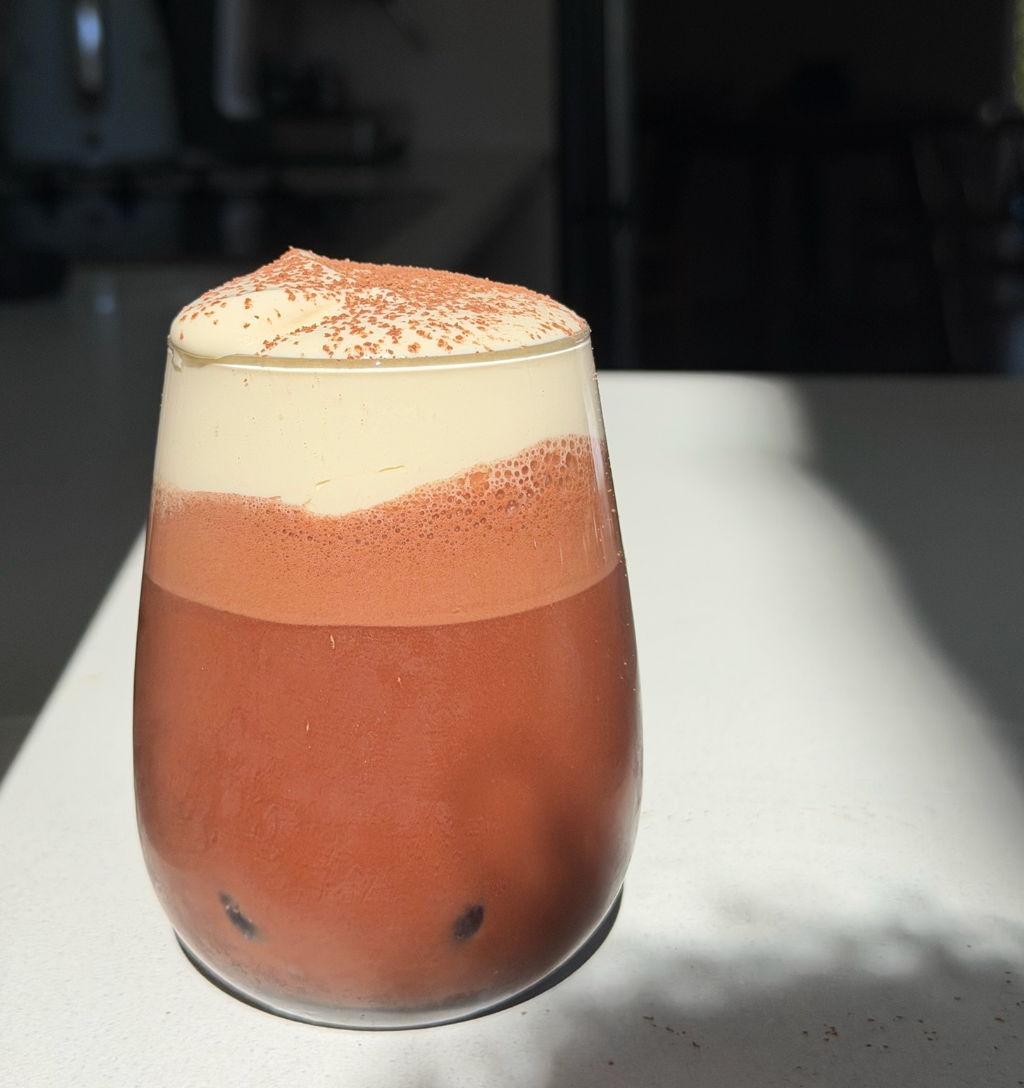 Iced bone broth cacao with coconut water and maple cold foam